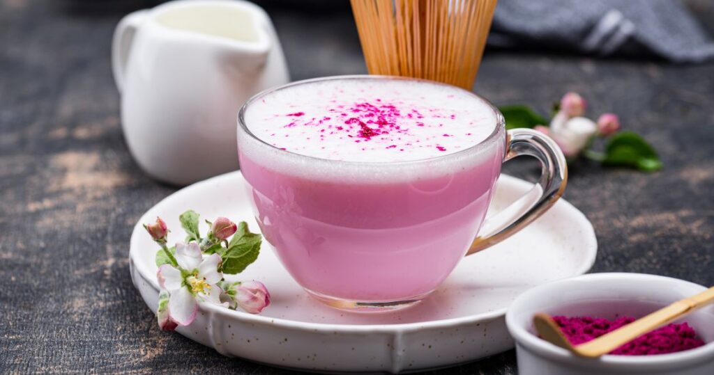 An image of a cup of rose milk garnished with rose petals